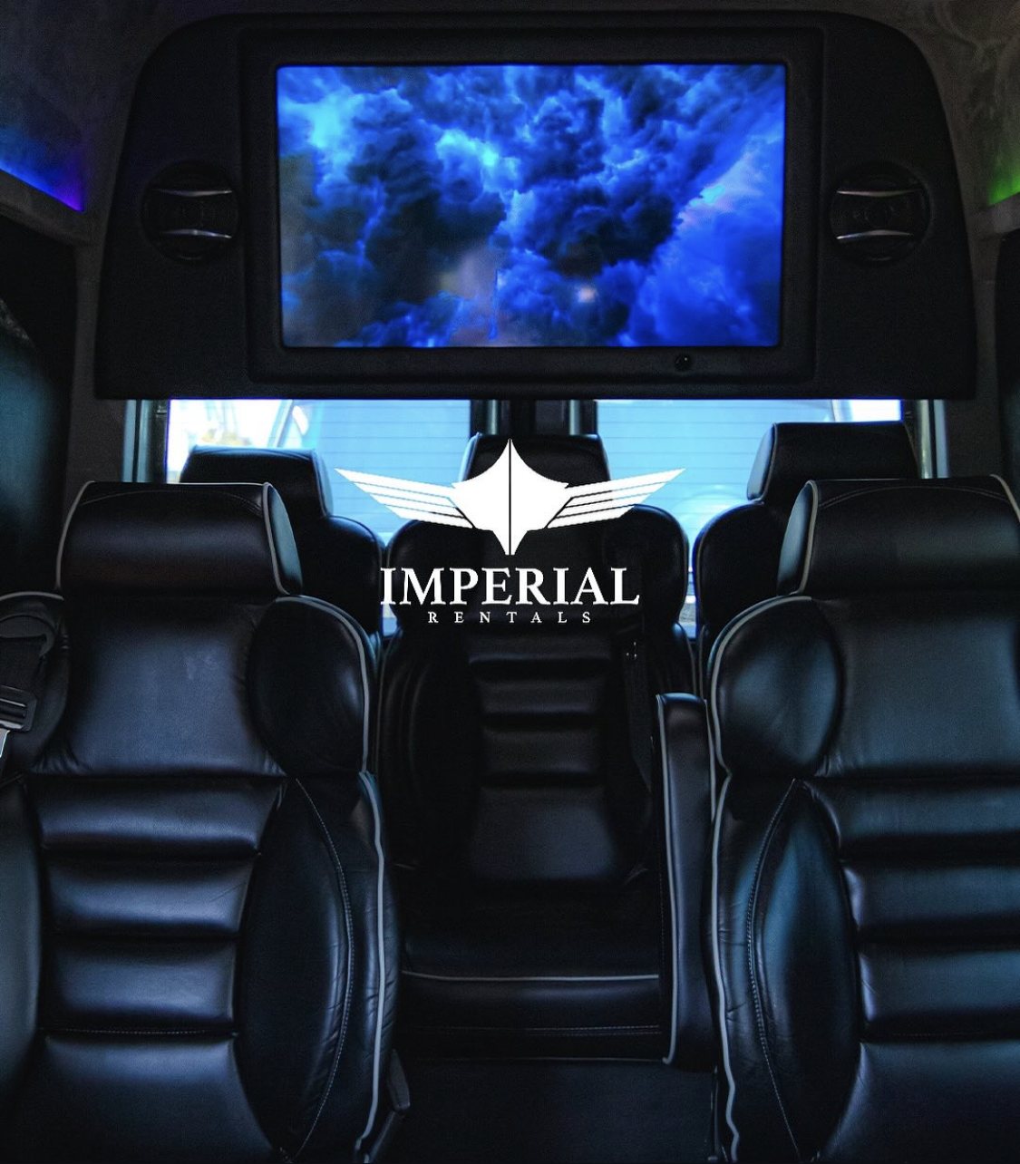 Executive Sprinter interior, black leather captain chairs facing the rear screen